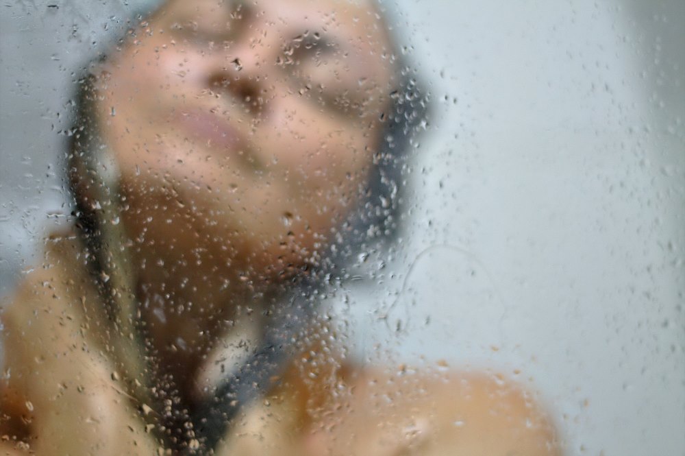 Frau entspannt unter der Dusche