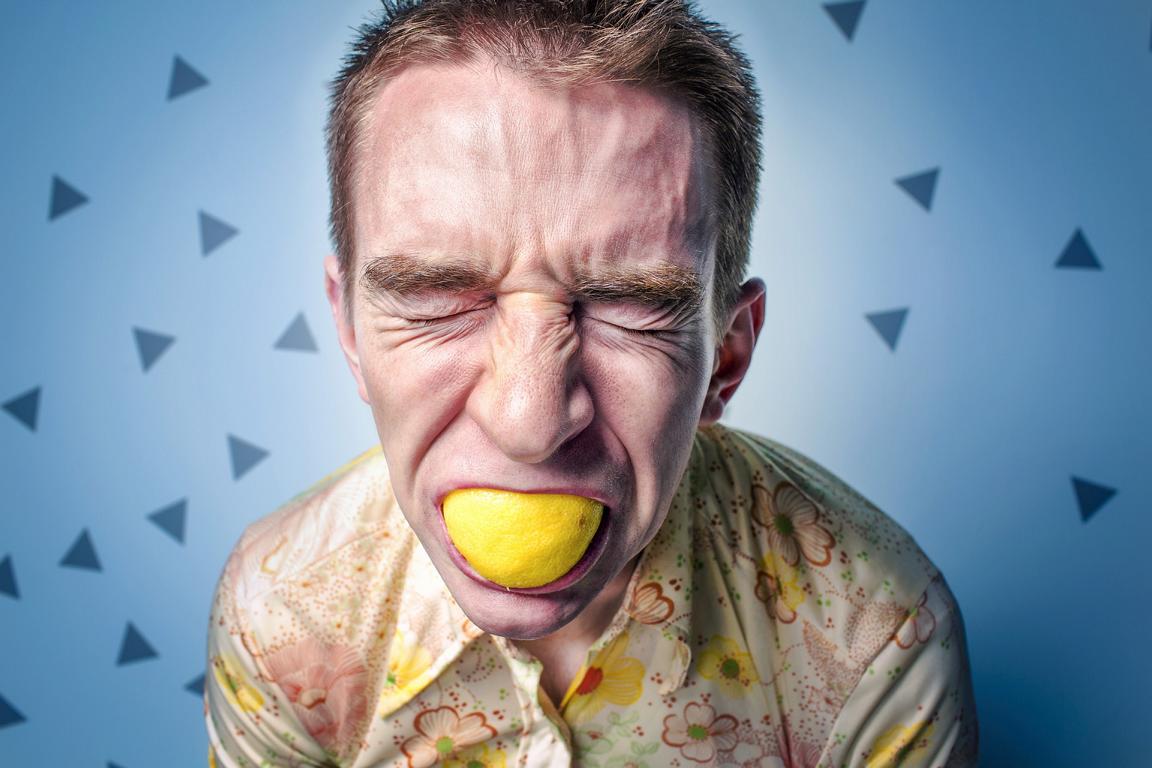 Mann mit Zitrone im Mund